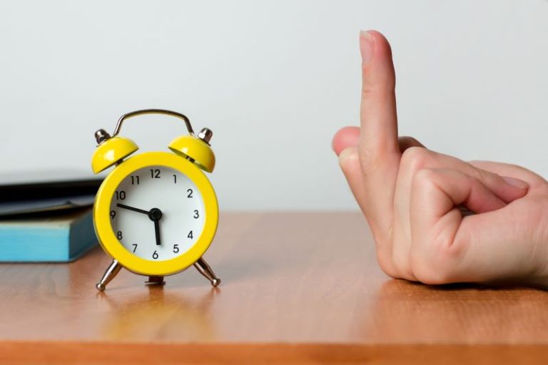 Yellow Clock with the middle finger being pointed at it