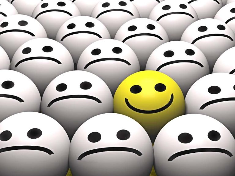 a single yellow smiley face among a sea of unhappy emojis