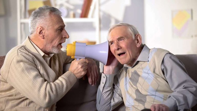 middle aged mad using a megaphone to talk to a old man