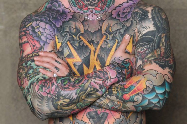 Male body arms crossed all over tattoo