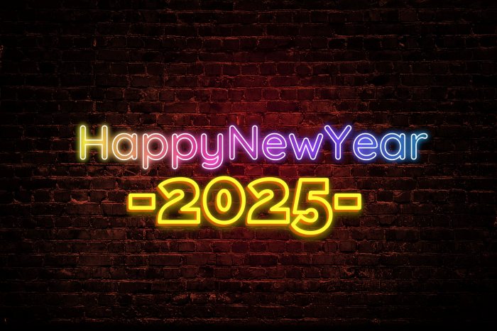 Happy New year 2025 colourful wording on a dark brick background