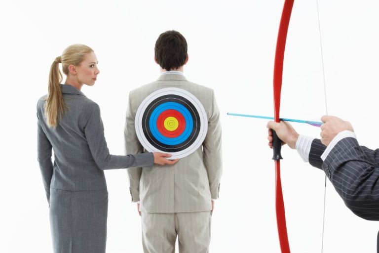 Business woman holding a target on the back of a man