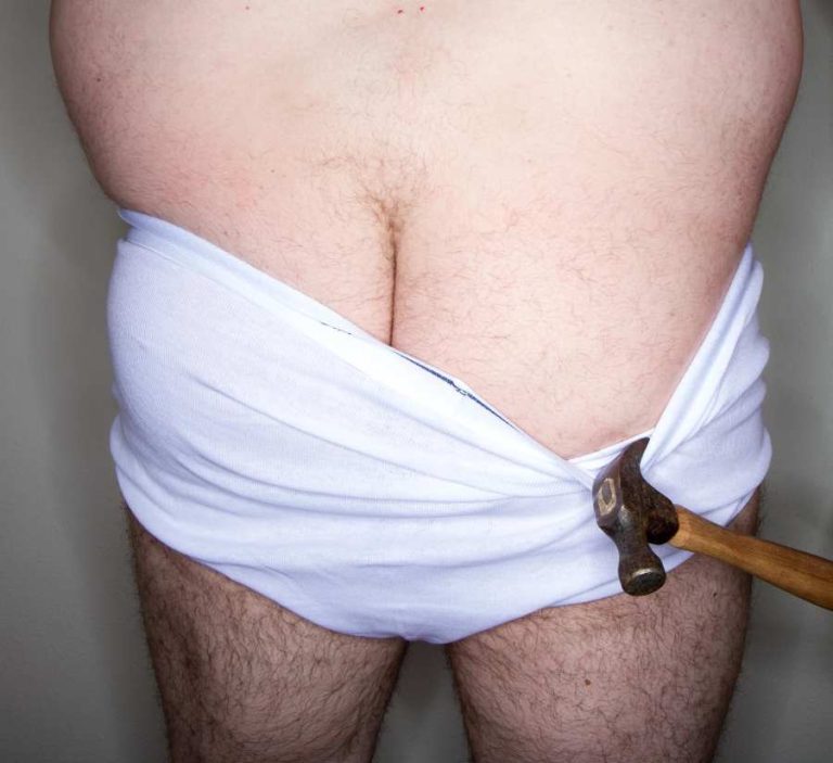 fat middle aged bum with a hammer pulling aside pants