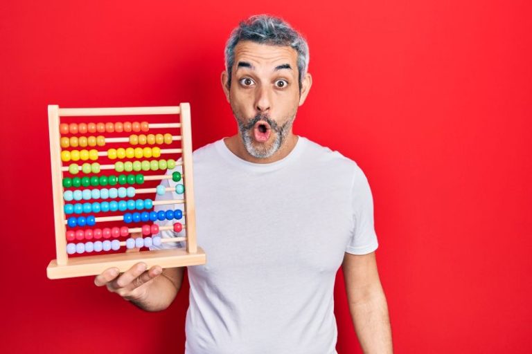 man in a white shirt against a red background. Holding an abacus
