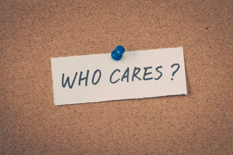 Corkboard with a note pinned to it, the note reads WHO CARES